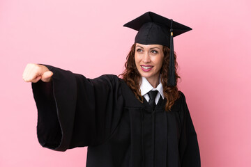 Young university graduate woman isolated on pink background giving a thumbs up gesture