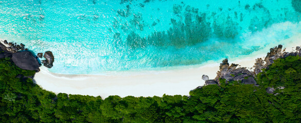 Aerial view of the island with white sand beach as the turquoise color wave water in green trees...