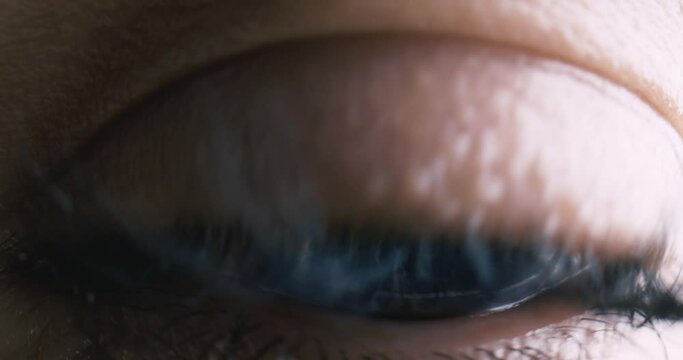 Blue Eye of girl looking at Camera Close Up. Macro Shot front view Opening and Closing Blue Eyes Little Girl. Close Up Motion of famele Eyes. Human eye iris opening pupil.
