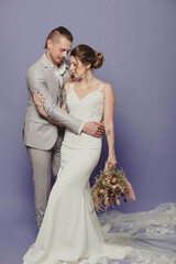 Portrait studio of a boho couple with a flower bouquet getting married