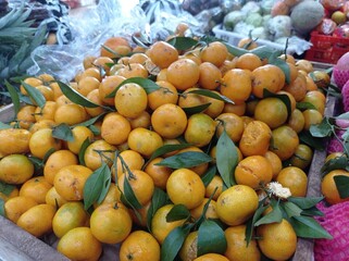 Naklejka na ściany i meble a photo of a citrus fruit being sold in a traditional market