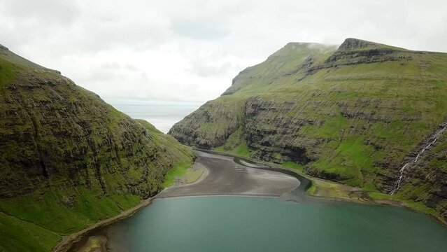 Aerial view of a lagoon in Saksun village, Faroe Islands. Lagoon in beautiful green nature in Saksun. Mist faroese nature. High quality 4k footage.