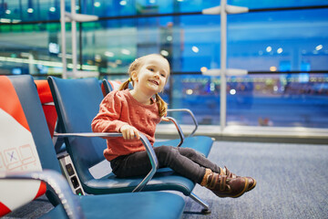 Adorable little preschooler girl traveling by plane