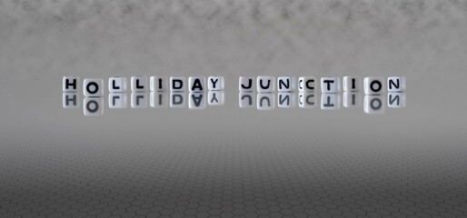 holliday junction word or concept represented by black and white letter cubes on a grey horizon background stretching to infinity - obrazy, fototapety, plakaty