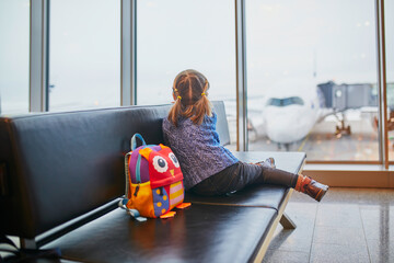 Adorable little preschooler girl traveling by plane