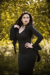 Young beautiful and mysterious Witch woman in black dress. Halloween holidays, magic time