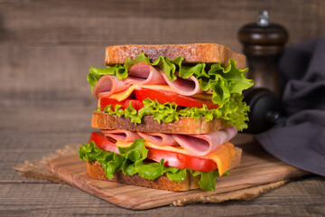 Club sandwich with ham, cheese, tomato and lettuce. 
