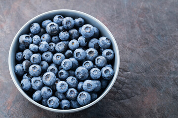Blueberry bowl on dark background. Fresh blueberries in a gray bowl. Top view. Copy space