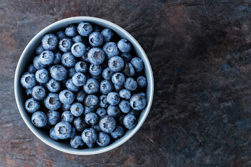 Blueberry bowl on dark background. Fresh blueberries in a gray bowl. Top view. Copy space