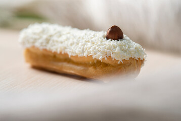 french eclair with coconut crumble hazelnut on a white desk