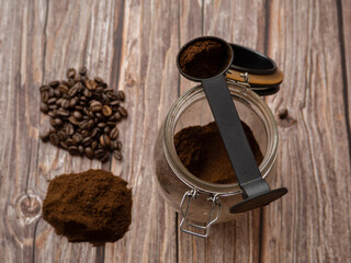 Pile of Ground coffee and coffee beans isolated on wooden background