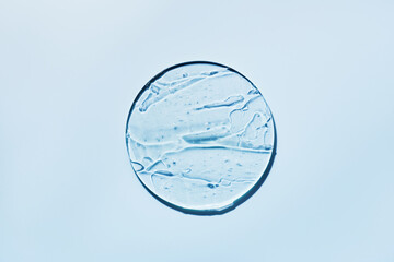 Sample of gels cosmetic product in petri dish on blue background, hard shadows. Abstract science,...