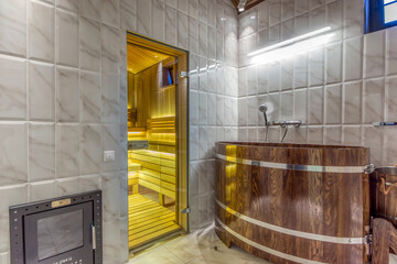 Modern wooden spa bath in the wellness center with white tile walls.