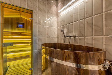 Modern wooden spa bath in the wellness center with white tile walls.