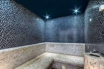 Turkish bath room in the SPA center with modern mosaic decor of white and black tiles.