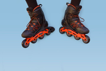 Two legs of a boy with inline skates facing each other on a blue background with copyspace