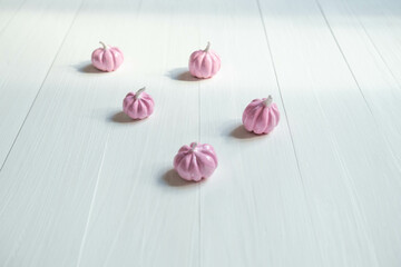pale pink pumpkins on a light background , a place for text , an abstract Halloween concept