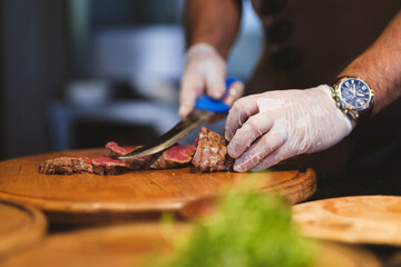 a chef cutting a fresh beef steak in the kitchen