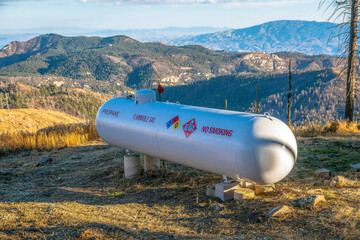 Propane flammable gas tank with mountains background on a sunny day