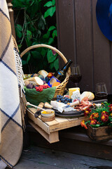 fall picnic with basket full of cheese, fig, grapes, honey and bagette. Marigolds flowers. Outdoor, picnic, brunch, fall mood