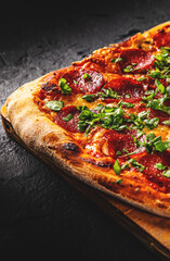 Pepperoni Pizza with Mozzarella cheese, salami, Tomato sauce, pepper, Spices. Italian pizza on Dark grey black slate background