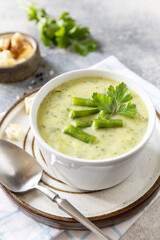 Healthy food. Vegan soup puree of green vegetables. Bowl of green bean and zucchini cream soup on a stone table. Copy space.