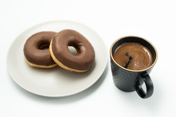 Coffee and Donut with chocolate glossy glaze in a plate, isolated on white background.
