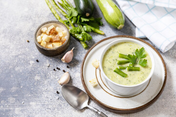 Vegan soup puree of green vegetables. Healthy food. Bowl of green bean and zucchini cream soup on a stone table. Copy space.