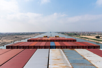 View on the top of the containers loaded on deck of the large cargo ship. She is sailing through...