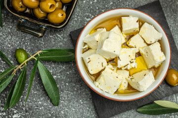 pickled feta cheese in bowl. Feta cheese marinated in olive oil. Restaurant menu, dieting, cookbook recipe top view