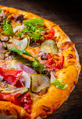 Pizza with Mozzarella cheese, Bolognese sauce, minced meat, bacon, tomato and vegetables. Italian pizza on wooden background.