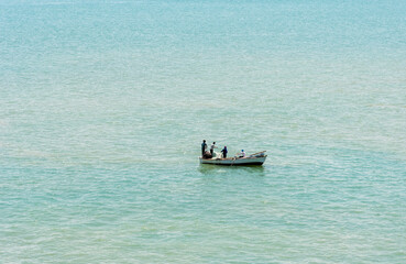Obraz premium Small Egyptian fishing boat with crew, people fishing in the Great Bitter Lake.