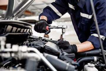 Car care maintenance and servicing, Close-up hand technician auto mechanic using the wrench to...