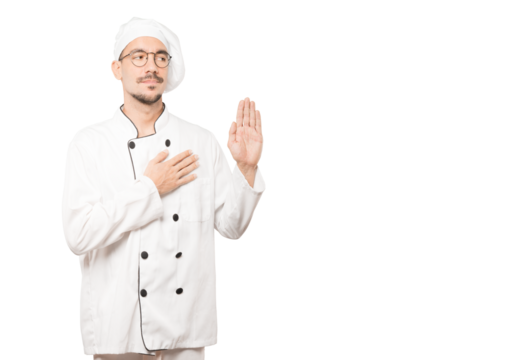 Serious young chef with a gesture of oath