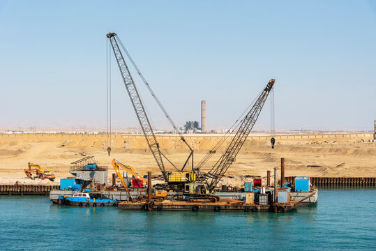 Floating cranes berthed at the bank of the Suez Canal, Egypt.