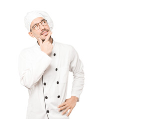 Happy young chef making a gesture of doubt