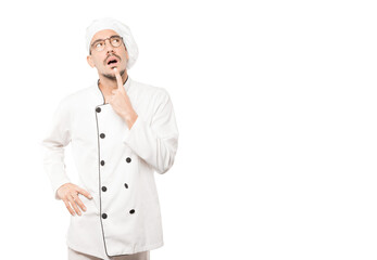 Surprised young chef making a gesture of doubt