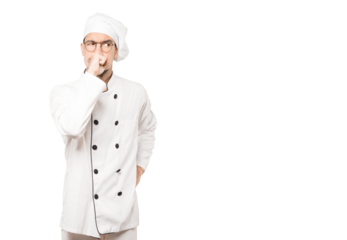 Angry young chef posing against background