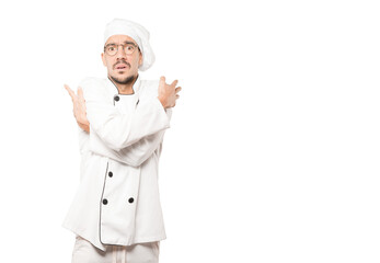 Concerned young chef making a gesture of being cold