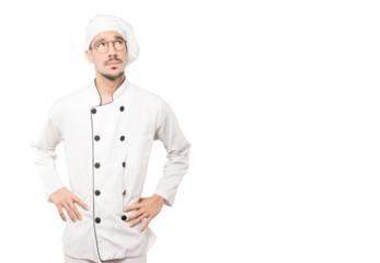 Serious young chef looking against background