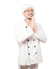 Concerned young chef praying gesture