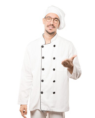 Young chef waving with his hand