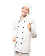 Amazed young chef pointing at you with his finger