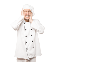 Concerned young chef worried about loud noises and covering his ears