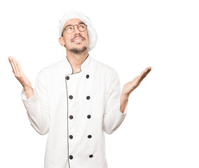 Astonished young chef looking up
