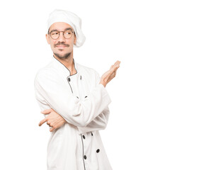 Puzzled young chef doing a gesture of not understand