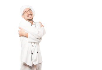Happy young chef doing a hug gesture