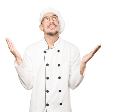 Astonished young chef looking up