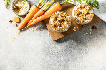 Healthy dessert. Vegan gluten-free pastry. Carrot cake with walnuts and cinnamon in a glass on a light background. View from above. Copy space.