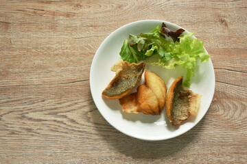 batter fried slice mango or Tilapia fish fresh vegetable salad on plate 